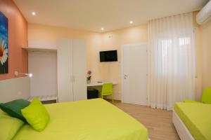 a bedroom with a yellow bed and a desk at b&b Rita, nel cuore del Salento in Cavallino di Lecce