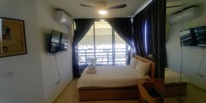 um pequeno quarto com uma cama e uma janela em Dizengoff Penthouse Boutique Hostel em Tel Aviv