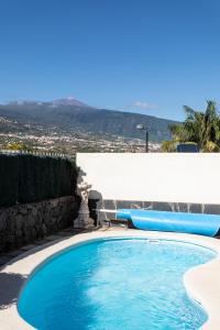 uma piscina com duas espreguiçadeiras ao lado em Dorina - Vivienda vacacional con piscina privada em La Orotava