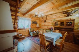ein Esszimmer mit einem Tisch und Stühlen in einer Hütte in der Unterkunft Trzy Stawy in Pysznica