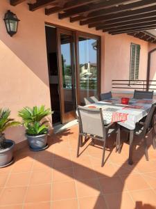 ペスキエーラ・デル・ガルダにあるEsclusivo trilocale con piscina al Garda Resort Villageのダイニングテーブルと椅子付きのパティオ