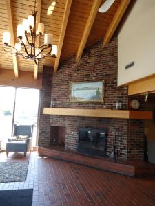 a brick fireplace in a living room with a chandelier at Travelodge by Wyndham Thunder Bay ON in Thunder Bay