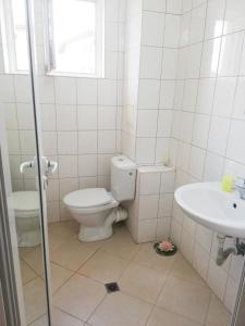 a bathroom with a toilet and a sink at Veda Guest House in Pomorie