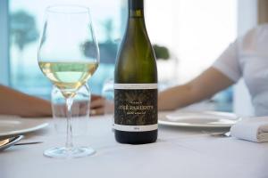 a bottle of white wine sitting next to a glass at Ocean Lounge in Altea