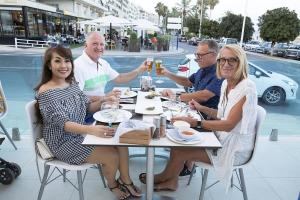 a group of people sitting at a table drinking beer at Ocean Lounge in Altea