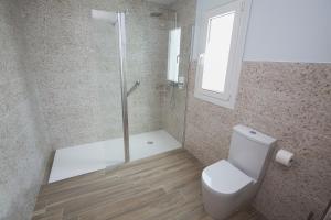 a bathroom with a shower and a toilet and a glass shower at Ocean Lounge in Altea