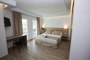 a bedroom with a bed and a desk and a television at Ocean Lounge in Altea