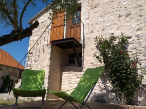 twee stoelen op een patio voor een gebouw bij La Chaumerie in Chenevelles