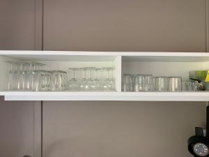 a white shelf with glasses on it at Chalet 3 chambres en Bois dans les landes n37 in Tosse