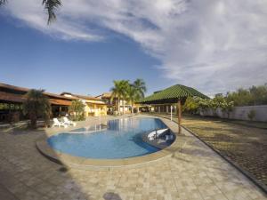 a swimming pool with a green umbrella and a building at Porto Dos Lençóis-Apt 12 in Barreirinhas