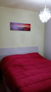 una camera con un letto rosso e un dipinto sul muro di Habitat Dolomiti-Cadore a Pieve di Cadore