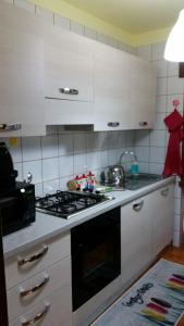皮耶韋迪卡多雷的住宿－Habitat Dolomiti-Cadore，厨房配有白色橱柜和炉灶烤箱。