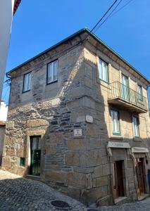 a stone building with a balcony on the side of it at Casa da Lurdinhas in Tabuaço