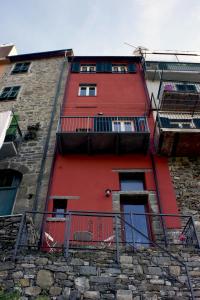 a red building with balconies on the side of it at Arbanella in Corniglia
