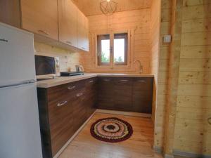 uma cozinha num chalé de madeira com um frigorífico em Domek drewniany em Piekielnik