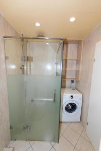 a shower stall in a bathroom with a washing machine at Brilliant Location in Ulaanbaatar