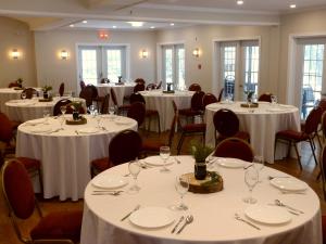 a room with tables and chairs with white tablecloths at Relais St-Denis in Saint-Sauveur-des-Monts