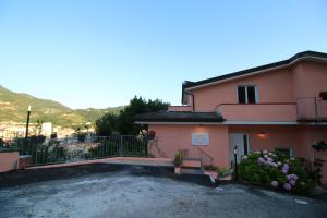 una casa rosa con un vialetto di fronte di B & B LA MARMIFERA a Carrara