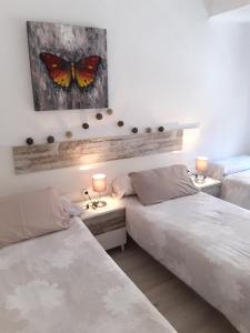 1 dormitorio con 2 camas y una pintura de mariposa en la pared en Apartamento Somosierra a 7 minutos del centro histórico, en Logroño
