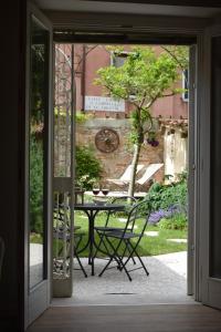 una porta aperta su un patio con tavolo e sedie di Ca' Corte San Rocco a Venezia