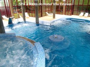 a large swimming pool in a hotel with blue water at Hotel Vila Esteves in Monção