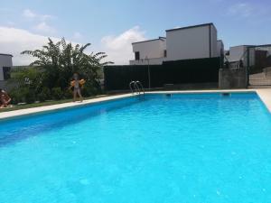 a young girl in a bikini standing next to a swimming pool at Villa Dalia in Suances