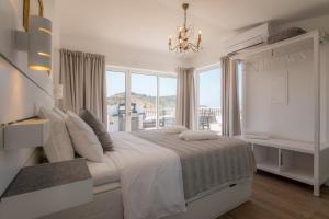a white bedroom with a large bed and a window at Casa Luisandra Boutique Hotel B&B in Luz
