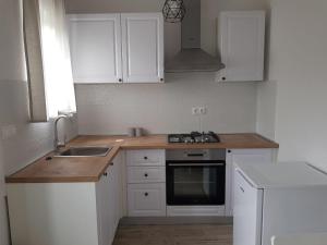 a kitchen with white cabinets and a sink and a stove at Judita in Jezera