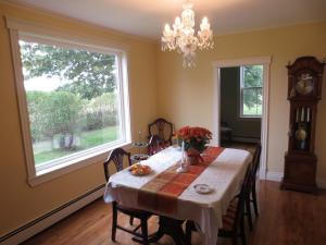 une salle à manger avec une table et une grande fenêtre dans l'établissement Sunbury Cove Winery, à Miscouche