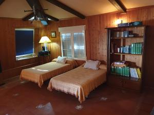 ラ・ローダにあるAmplia y luminosa buhardilla & total independenciaのベッドルーム(ベッド2台、本棚付)