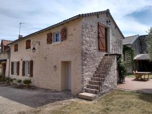 a stone house with a staircase on the side of it at La Chaumerie in Chenevelles