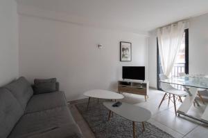 een witte woonkamer met een bank en een tafel bij 303 - Appartement Duplex Moderne - Jeanne d'Arc, Toulouse in Toulouse