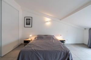 een witte kamer met een bed en twee nachtkastjes bij 303 - Appartement Duplex Moderne - Jeanne d'Arc, Toulouse in Toulouse