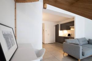 een woonkamer met een blauwe bank en een keuken bij 303 - Appartement Duplex Moderne - Jeanne d'Arc, Toulouse in Toulouse