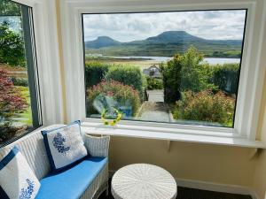a room with a window with a couch and a view at Easan Dubh in Dunvegan