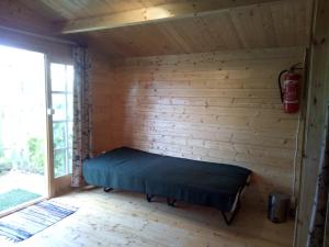 ein Zimmer mit Bett in einer Blockhütte in der Unterkunft E.A.MINIKAMP in Lelle