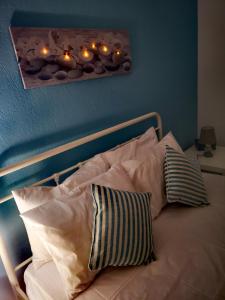 a bed with white pillows and lights on a wall at Casa Verde in Perea
