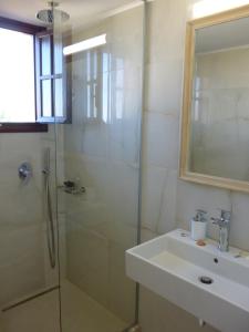 a bathroom with a glass shower and a sink at Romanza in Kalamaki