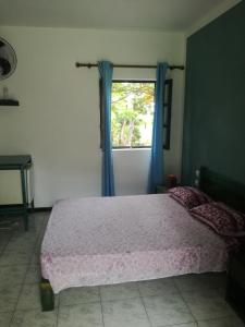 ein Schlafzimmer mit einem rosa Bett und einem Fenster in der Unterkunft Aldeia Jerome in Paul