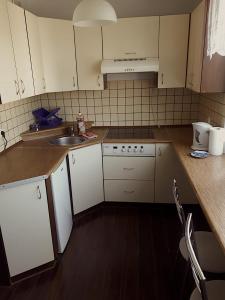 a small kitchen with white cabinets and a sink at Kwatera Jolanta in Ełk