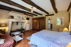 een slaapkamer met een groot bed in een kamer bij Chambres d'hôtes Noailles in Puisseguin