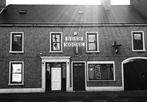 ein Buschhaus mit einem Schild davor in der Unterkunft Bush House Accommodation - The Courthouse Apartment in Bushmills