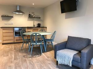 a living room with a table and chairs and a couch at Bush House Accommodation - The Courthouse Apartment in Bushmills