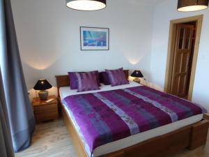 a bedroom with a bed with purple sheets and two lamps at THE VIEW **** in Račišće