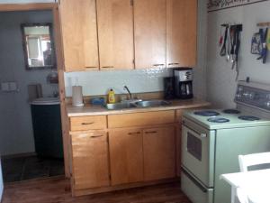 a kitchen with wooden cabinets and a sink and a stove at Marble Lake Lodge in Cloyne