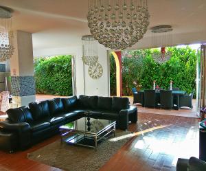 a living room with a black leather couch and a table at Casa Viera in Buzanada