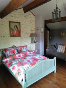 een slaapkamer met een bed en een bank in een kamer bij La Chaumerie in Chenevelles