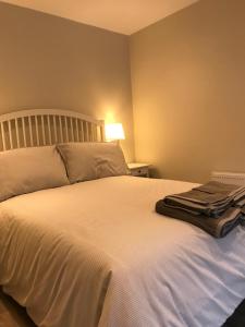 ein Schlafzimmer mit einem großen weißen Bett mit einer Lampe in der Unterkunft Bush House Accommodation - The Courthouse Apartment in Bushmills