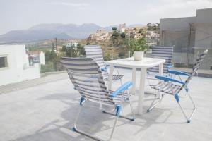 a white table and chairs on a balcony at Villa Miron in Kamilari