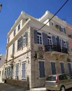 a building with a car parked in front of it at Fiera Guesthouse in Ermoupoli